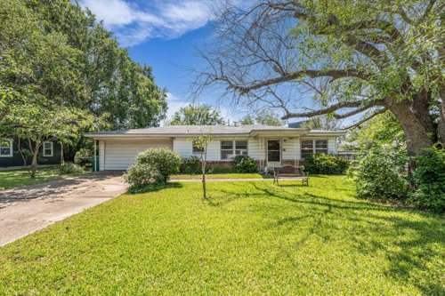 Single story home featuring concrete driveway and a front yard