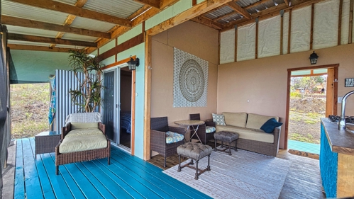 Open-air living room with relaxed seating and natural flow to the outdoors—enjoy ocean views and indoor-outdoor island living on Hawai‘i Island.