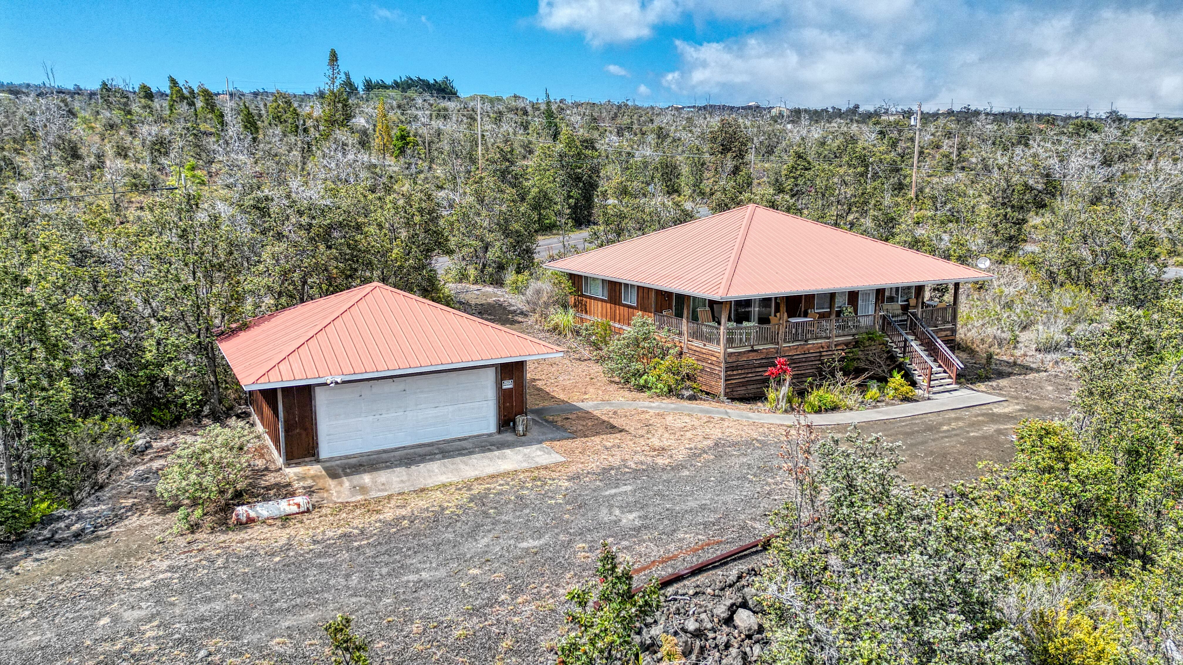 Elevated 3-bed, 2-bath home with detached 2-car garage on a full acre in Ocean View. Metal roofs, covered lanai, and private setting surrounded by native forest. Clean, classic, and ready to move in.