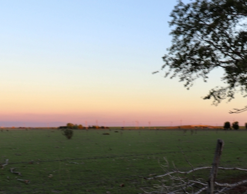 Sunset over fenced acreage at 504 Redwood Avenue, a ±72-acre property for sale in Adrian, Texas.